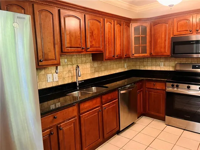a kitchen with stainless steel appliances granite countertop a stove a sink and a microwave