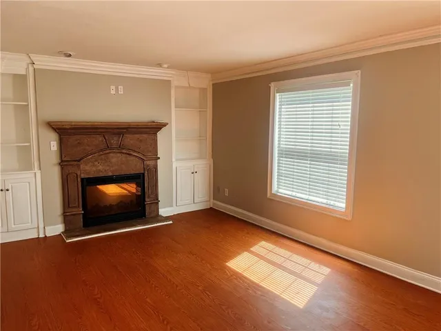 a view of an empty room with a fireplace and a window