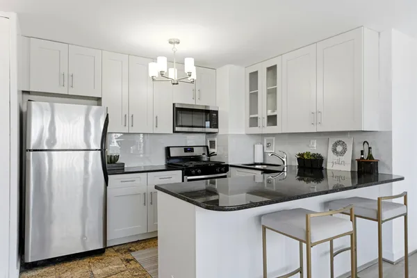 a kitchen with stainless steel appliances granite countertop a stove and a microwave