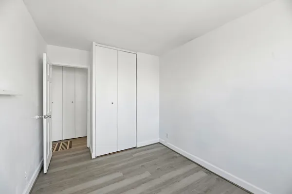 a view of an empty room with a window and fire place