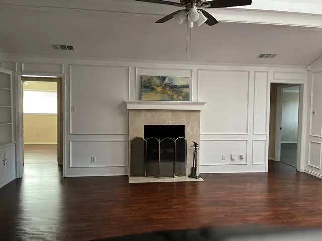 a view of a livingroom with wooden floor and a fireplace