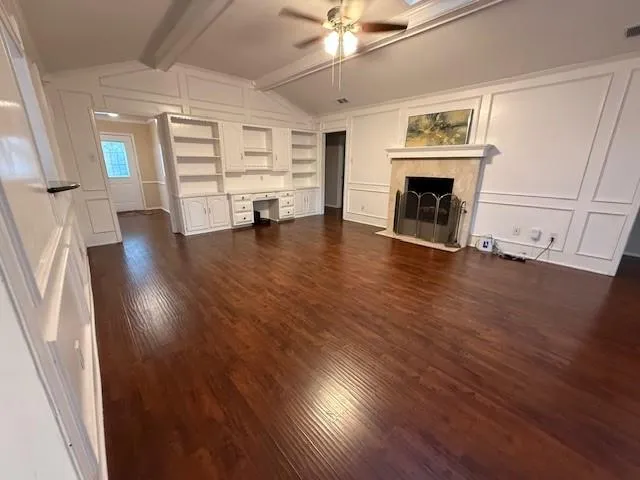 a view of a livingroom with wooden floor and a fireplace