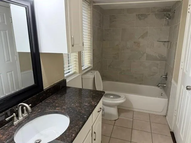 a bathroom with a granite countertop sink toilet a mirror and shower