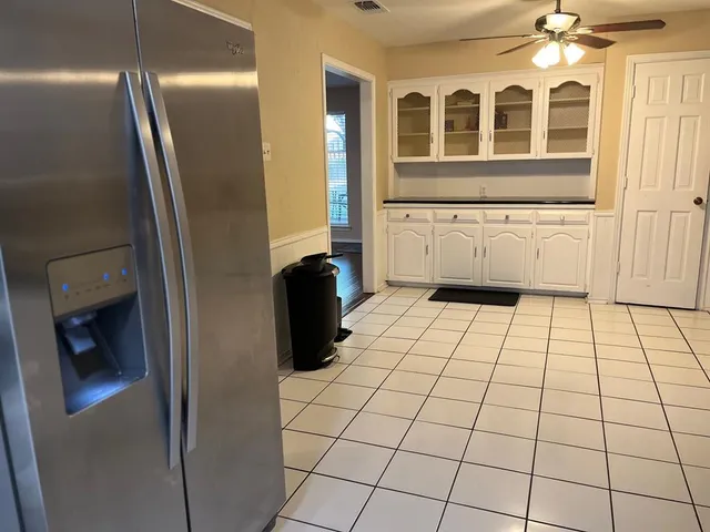 a view of an empty room and a refrigerator