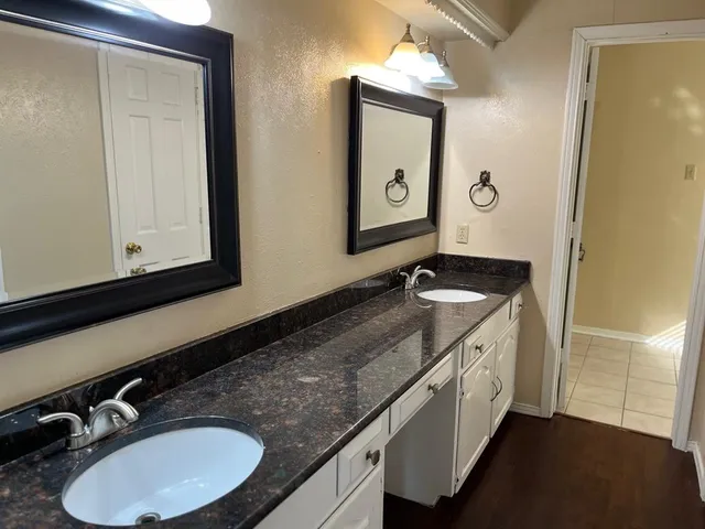 a bathroom with a granite countertop sink and a mirror