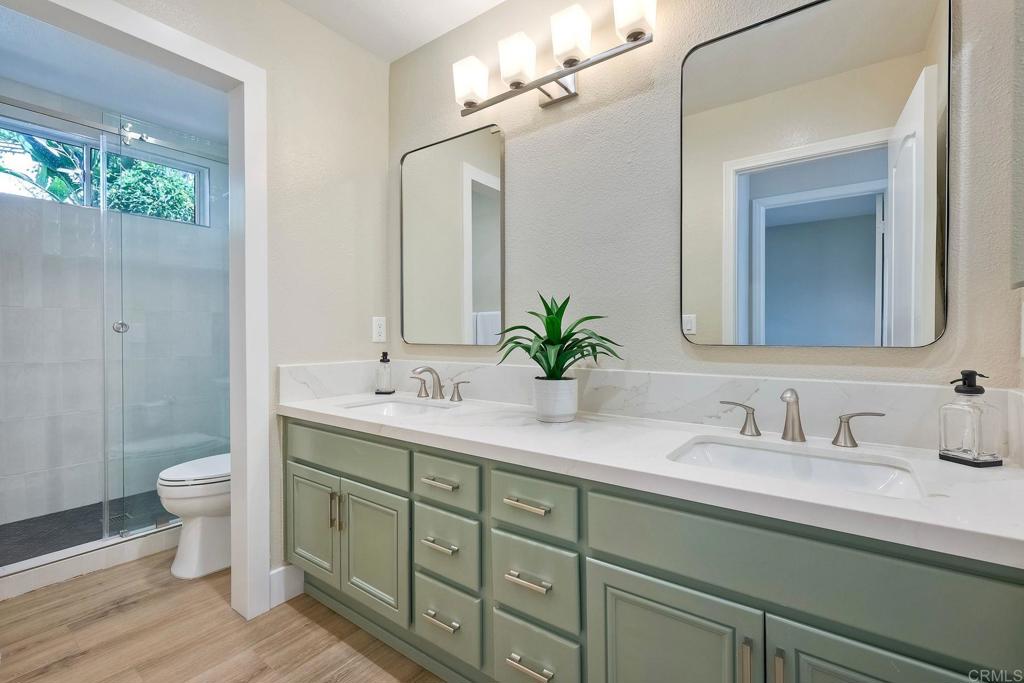 7165 Willet Circle Carlsbad, CA 92011 - Photo 27 of 65 a bathroom with a double vanity sink toilet and a mirror