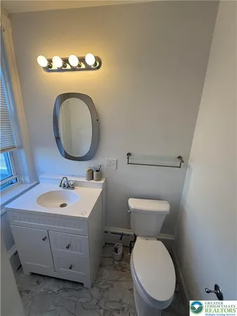 a bathroom with a toilet sink and mirror