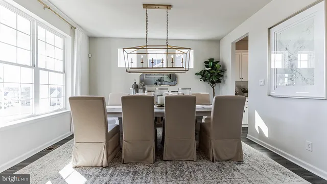 a dining room with furniture a chandelier and wooden floor