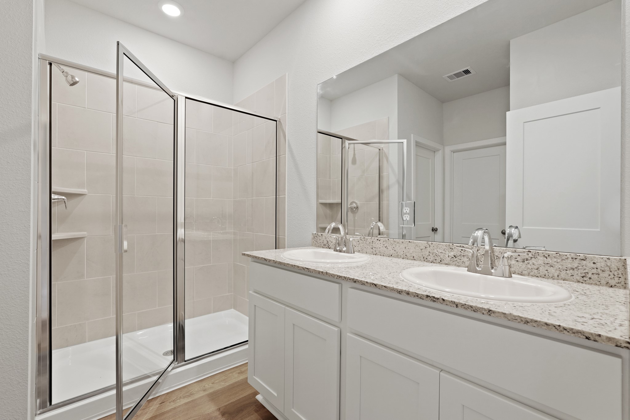 17202 King Eider Road Waller, TX 77484 - Photo 9 of 29 a bathroom with a granite countertop sink a mirror a vanity and a shower