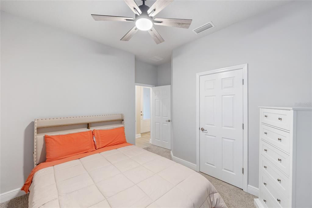11720 Chevelon Lane Parrish, FL 34219 - Photo 20 of 70 a bedroom with a bed and a chandelier
