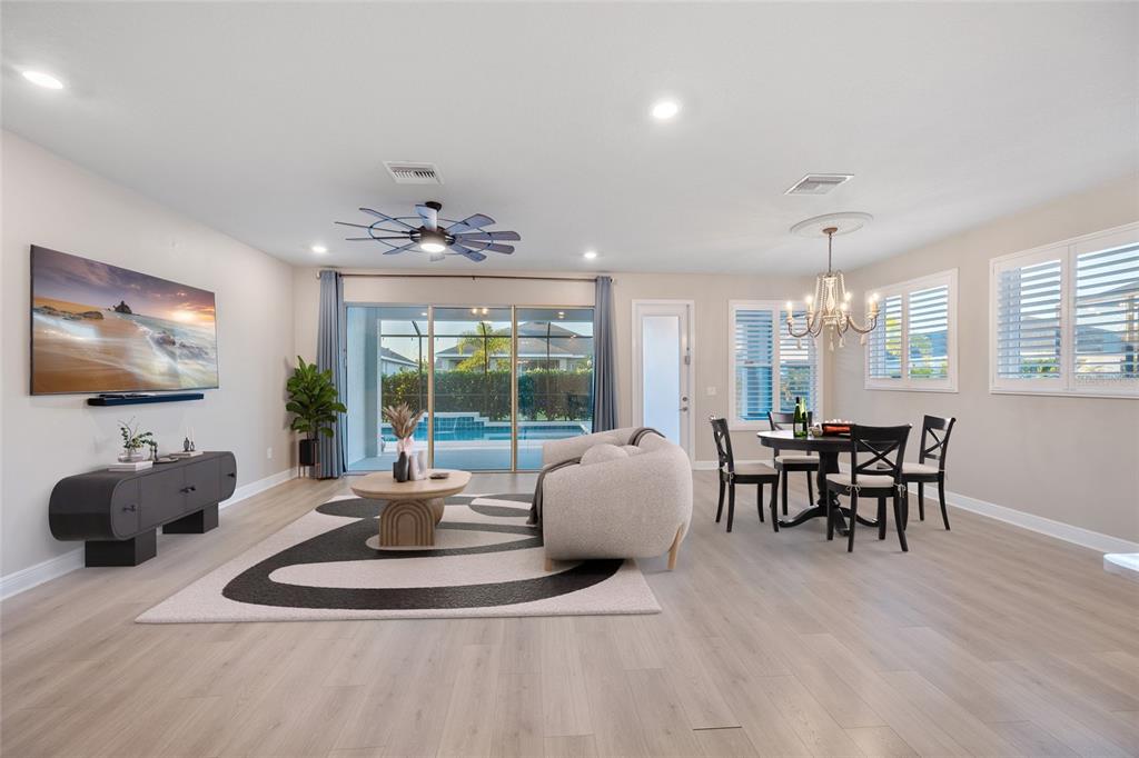11720 Chevelon Lane Parrish, FL 34219 - Photo 5 of 70 a living room with furniture a chandelier a large window and a dining table
