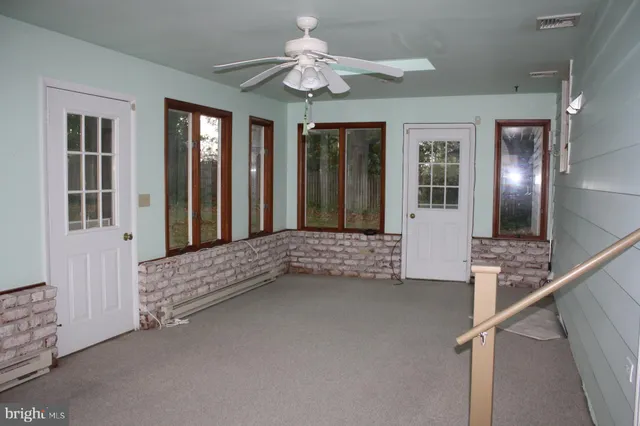 a view of staircase with a ceiling fan and a window