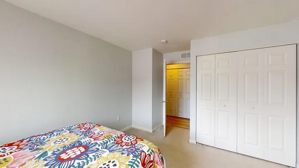 a bedroom with a bed and a painting on the wall