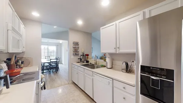a kitchen with appliances a sink and cabinets