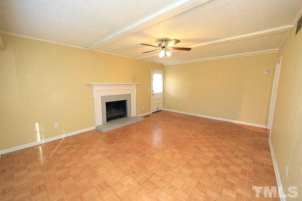 6628 Keystone Drive Raleigh, NC 27612 - Photo 16 of 28 The family room-not staged (lots of great wall space and options for furniture placement). There is a gas log fireplace with brick surround.