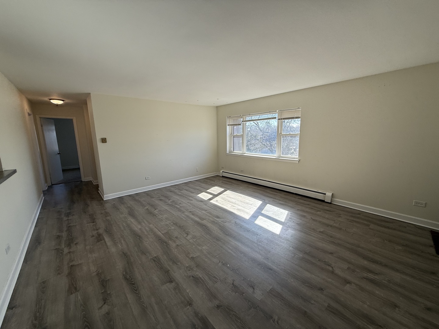 1039 College Avenue, Unit 10E Wheaton, IL 60187 - Photo 2 of 16 an empty room with wooden floor and windows