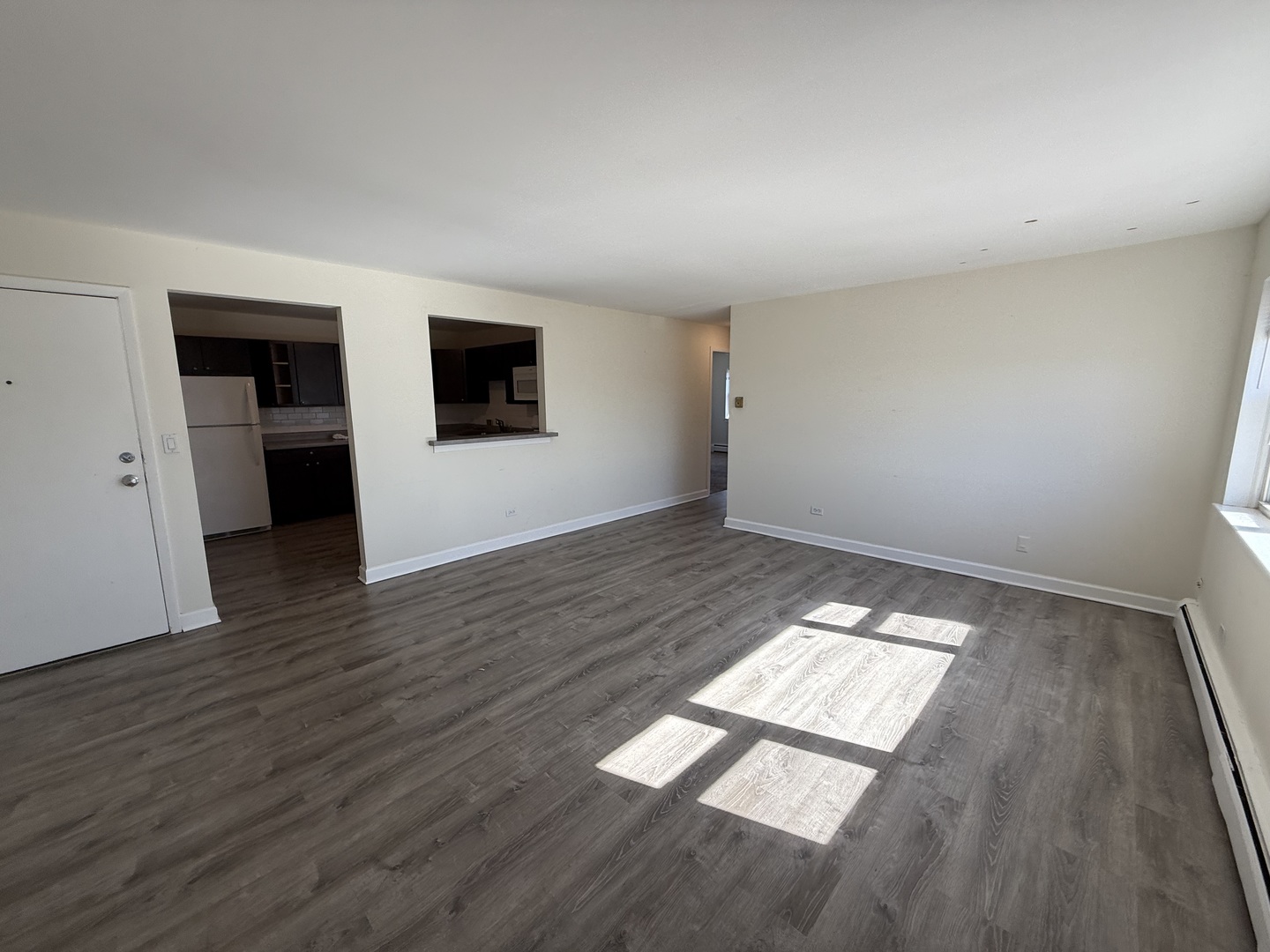 1039 College Avenue, Unit 10E Wheaton, IL 60187 - Photo 3 of 16 an empty room with wooden floor and windows