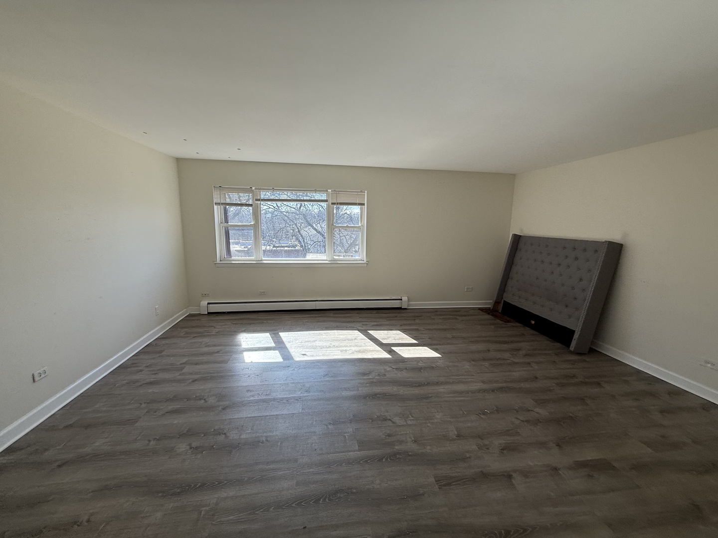 1039 College Avenue, Unit 10E Wheaton, IL 60187 - Photo 5 of 16 an empty room with wooden floor and windows