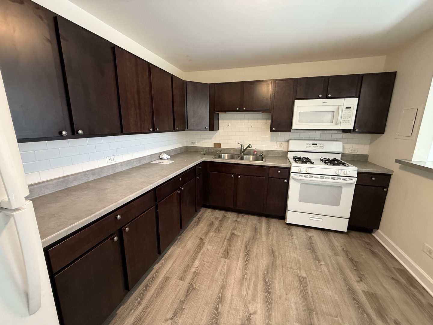 1039 College Avenue, Unit 10E Wheaton, IL 60187 - Photo 8 of 16 a kitchen with stainless steel appliances a sink a stove a refrigerator and cabinets