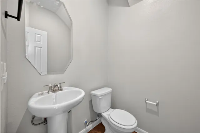 a bathroom with a sink a toilet and mirror