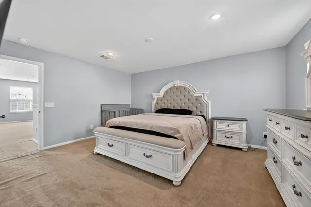 a spacious bedroom with a bed and a cabinets
