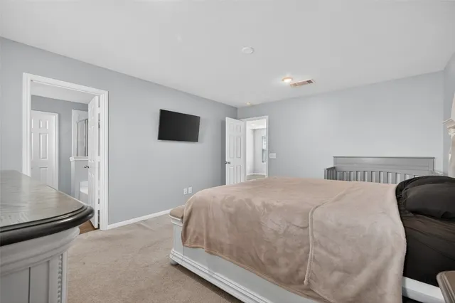 a bedroom with a bed and a flat screen tv