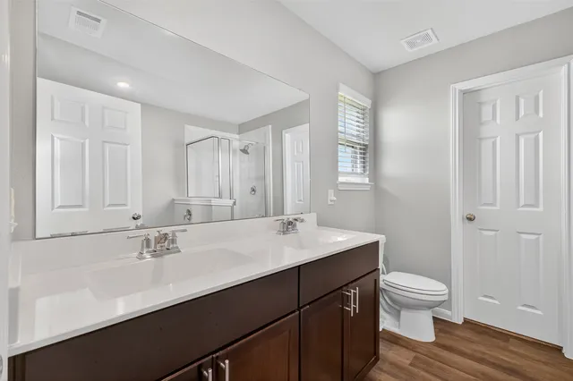 a bathroom with a sink a toilet a shower and a mirror