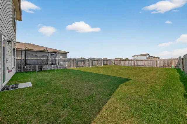 a view of a big room with a big yard and large trees