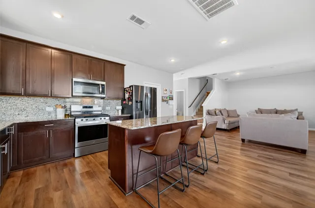 a kitchen with stainless steel appliances wooden floors and wooden cabinets