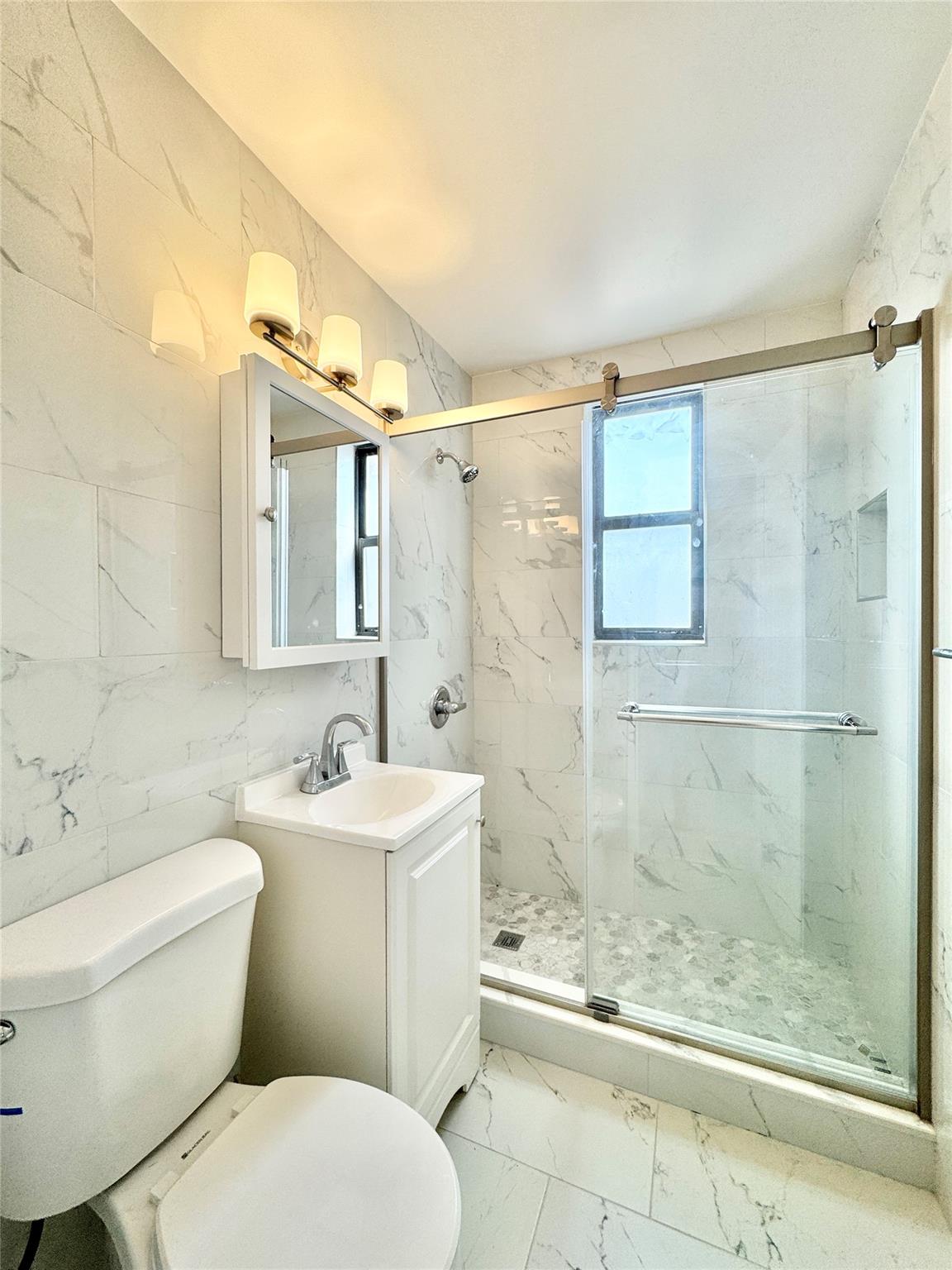 84-19 51st Avenue, Unit 5E Queens, NY 11373 - Photo 1 of 8 a bathroom with a toilet sink and shower