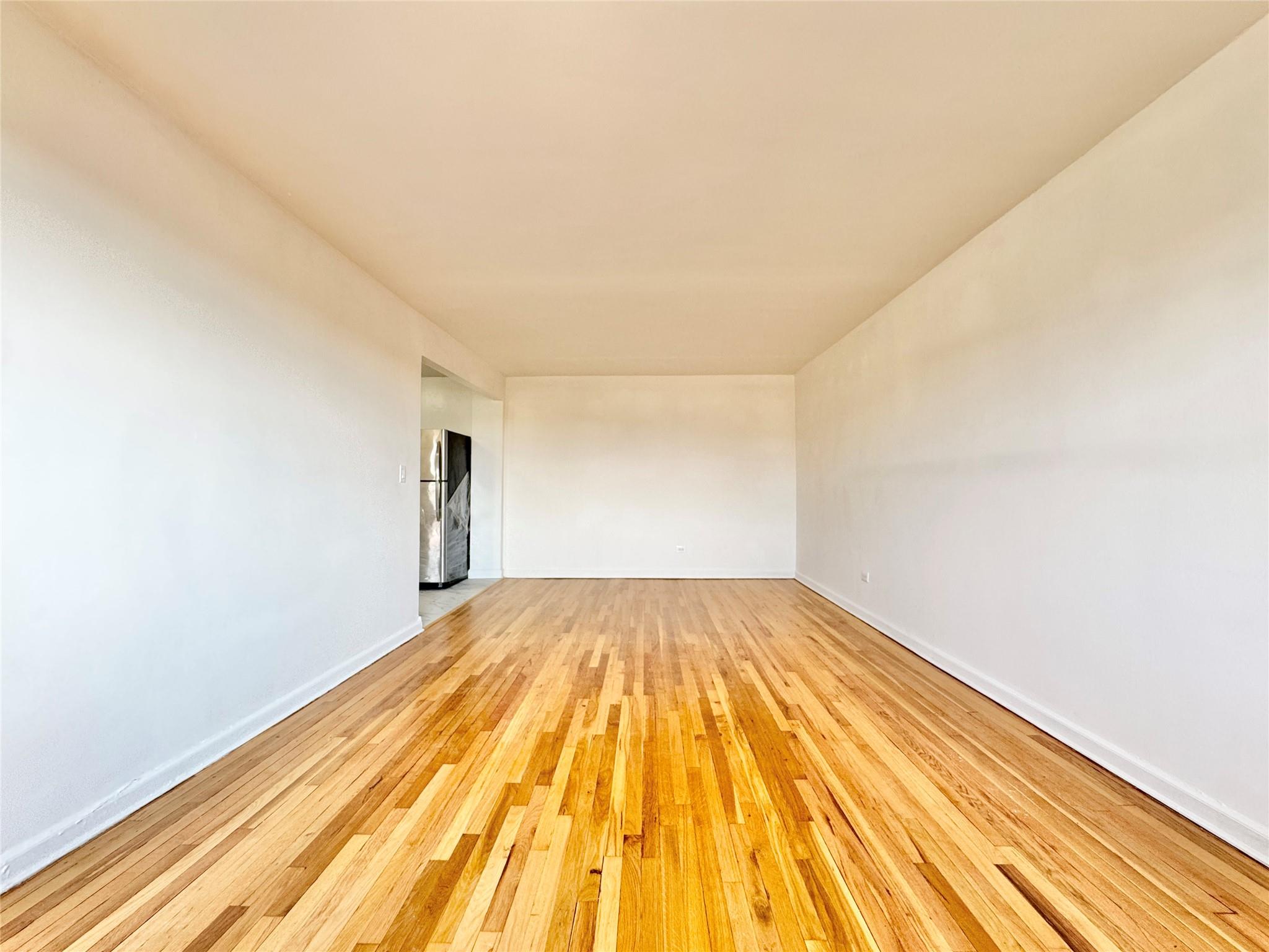 84-19 51st Avenue, Unit 5E Queens, NY 11373 - Photo 5 of 8 a view of a room with wooden floor