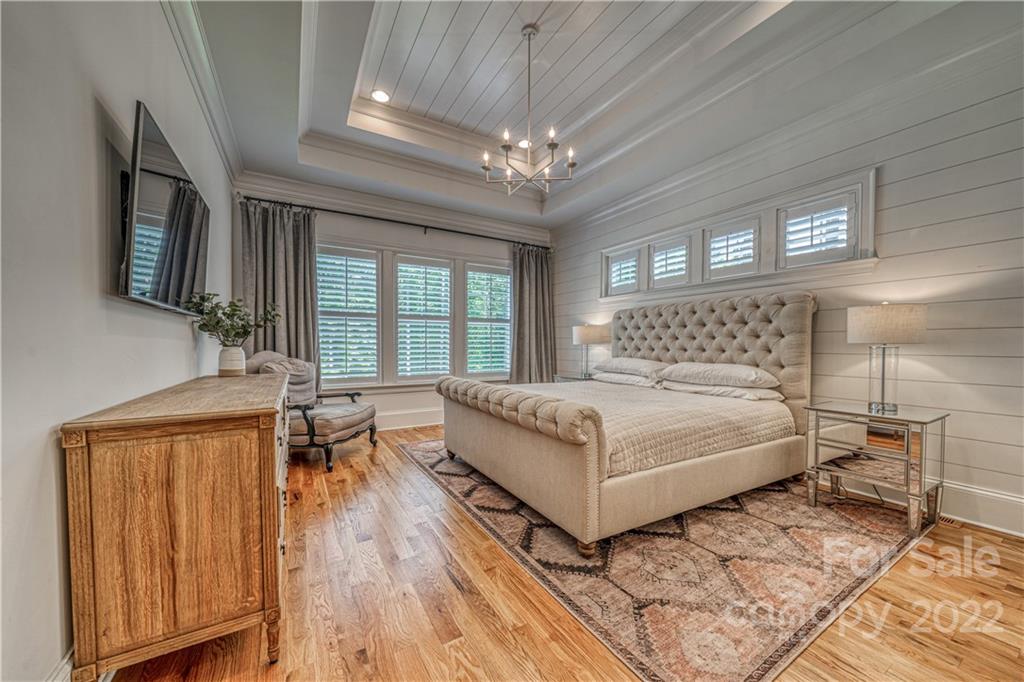 4026 Country Overlook Drive Fort Mill, SC 29715 - Photo 12 of 43 a bedroom with a large bed a chandelier and windows