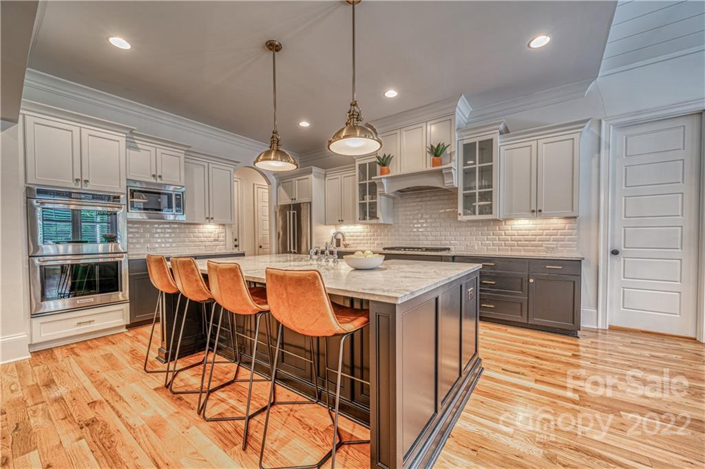 4026 Country Overlook Drive Fort Mill, SC 29715 - Photo 19 of 43 a kitchen with stainless steel appliances granite countertop a kitchen island a stove a sink a dining table and chairs