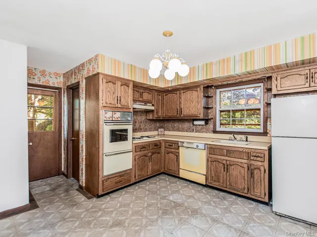 a kitchen with stainless steel appliances granite countertop a refrigerator and a stove top oven