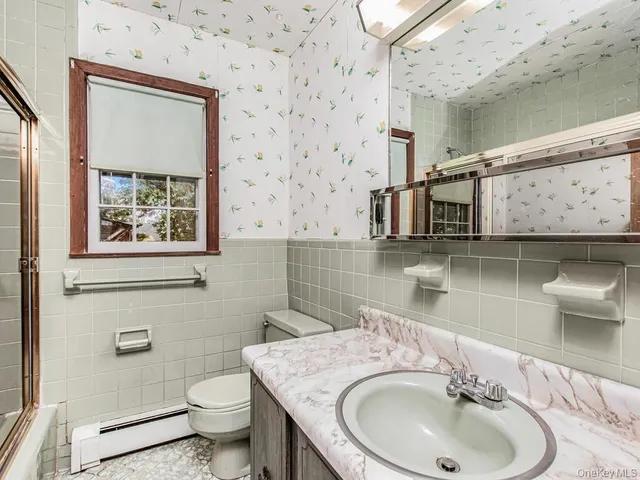 a bathroom with a toilet sink and mirror