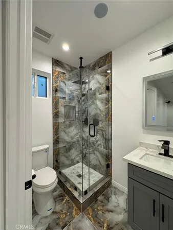 a bathroom with a shower a toilet and a sink