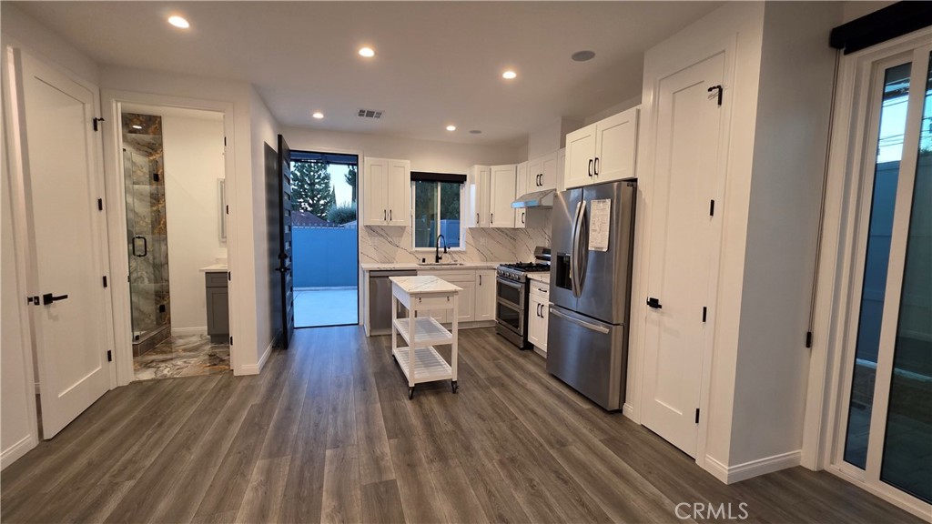 18222 Chatsworth Street Porter Ranch, CA 91326 - Photo 24 of 41 a kitchen with stainless steel appliances a refrigerator and wooden floor