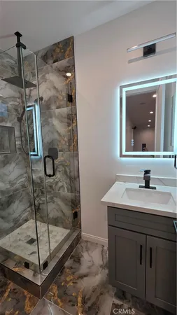 a bathroom with a shower sink and mirror