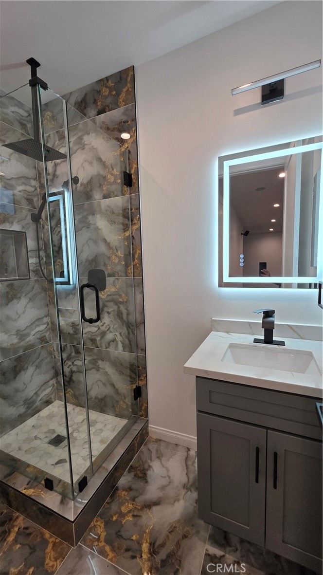 18222 Chatsworth Street Porter Ranch, CA 91326 - Photo 26 of 41 a bathroom with a shower sink and mirror
