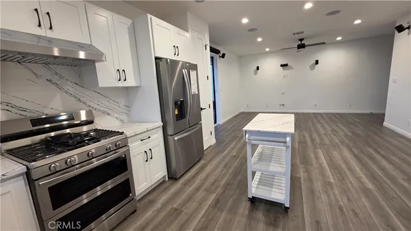 a kitchen with wooden floor and a stove top oven