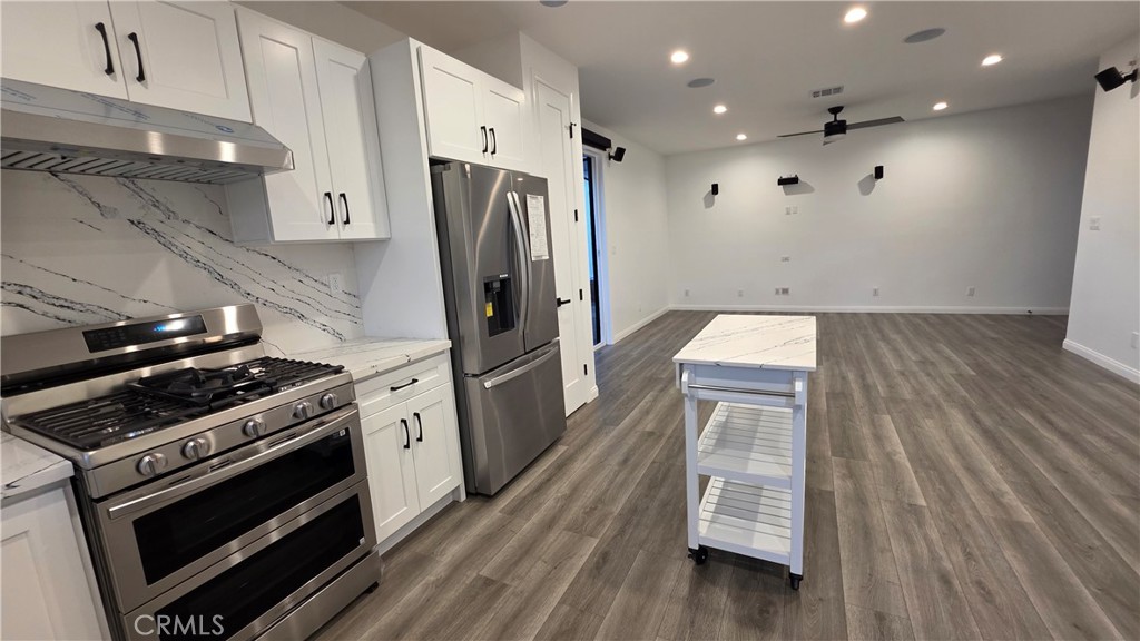 18222 Chatsworth Street Porter Ranch, CA 91326 - Photo 27 of 41 a kitchen with wooden floor and a stove top oven