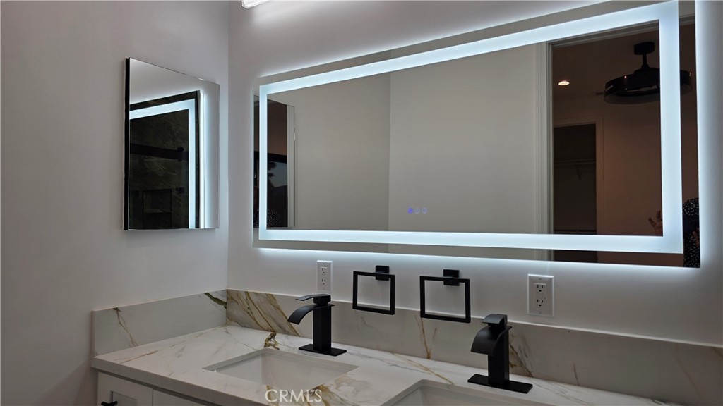 18222 Chatsworth Street Porter Ranch, CA 91326 - Photo 30 of 41 a bathroom with a granite countertop sink and a mirror