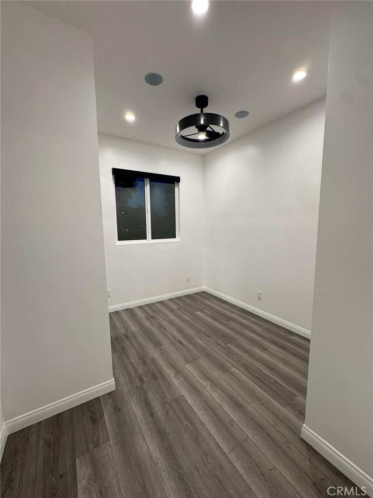 18222 Chatsworth Street Porter Ranch, CA 91326 - Photo 5 of 41 a view of an empty room with a ceiling fan and wooden floor