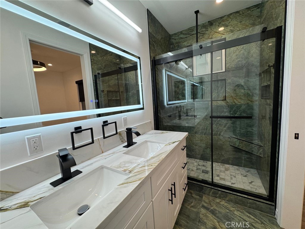 18222 Chatsworth Street Porter Ranch, CA 91326 - Photo 8 of 41 a bathroom with a shower sink and mirror