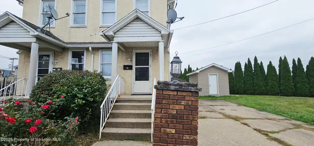 a view of a house with backyard and trees