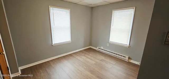a view of a room with wooden floor and window
