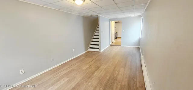 a view of a hallway with wooden floor and entryway