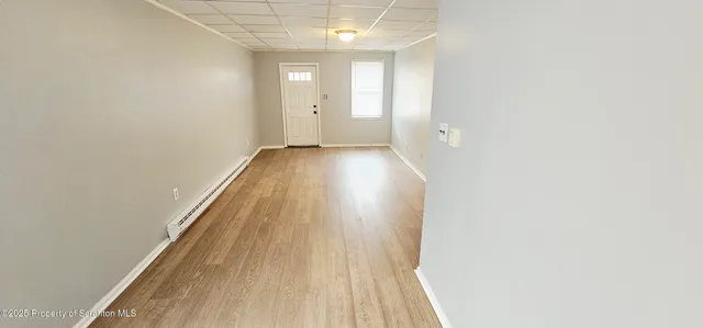 a view of a room with wooden floor and a ceiling fan