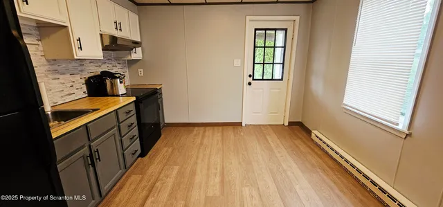 a kitchen with a sink and wooden floor