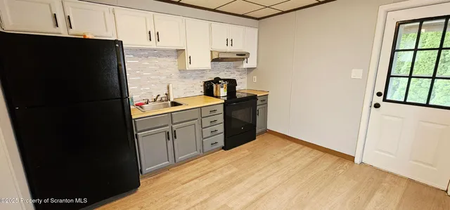 a kitchen with stainless steel appliances granite countertop a refrigerator a stove a sink and dishwasher with wooden floor